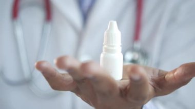 Doktor bir göz damlası tutuyor. Yakından. 