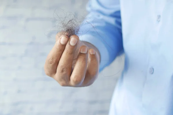 Homem segurar sua lista cabelo perto — Fotografia de Stock