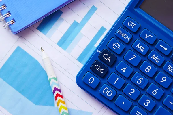 Közelkép a kék számológép és a pénzügyi diagram az asztalon. — Stock Fotó