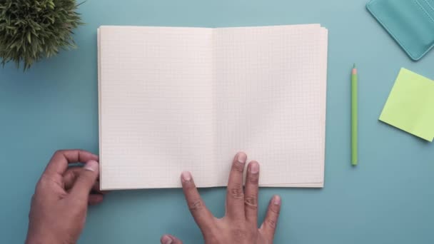Вид сверху руки человека, поворачивающего пейджер дневника — стоковое видео