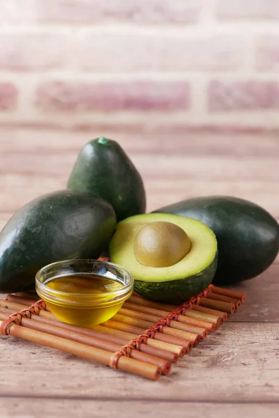 Olie en plak avocado op houten tafel — Stockfoto