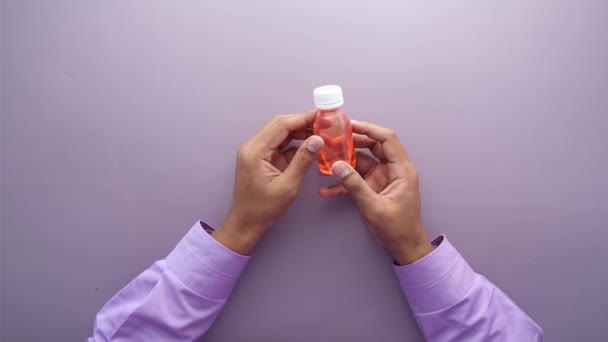 Bouteille de maintien avec médecine liquide sur fond violet — Video