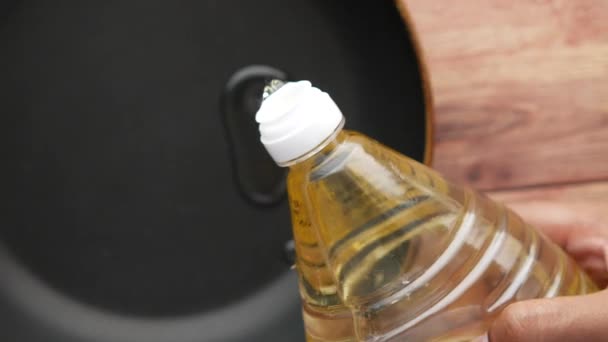 Pouring sunflower oil on a cooking pan top view — Vídeo de stock