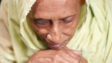 a sad senior asian women looking down 