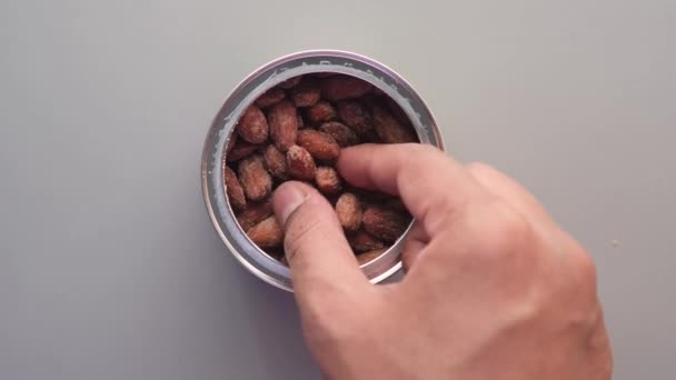 Hand pick almond nut from a container — Stockvideo