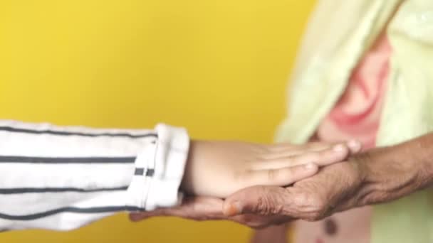 Detail shot van kind meisje houden hand van een senior vrouwen — Stockvideo