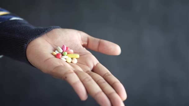 Mans χέρι με το φάρμακο χυθεί έξω από το δοχείο χάπι — Αρχείο Βίντεο