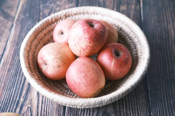 Närbild av färskt äpple i en skål på träbord — Stockfoto