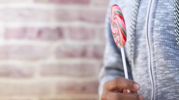 Boy hand holding lollipop with copy space — Vídeos de Stock