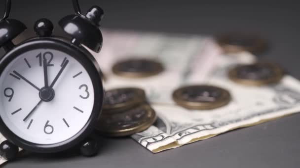 Old alarm clock, coins and cash on black — Stok video