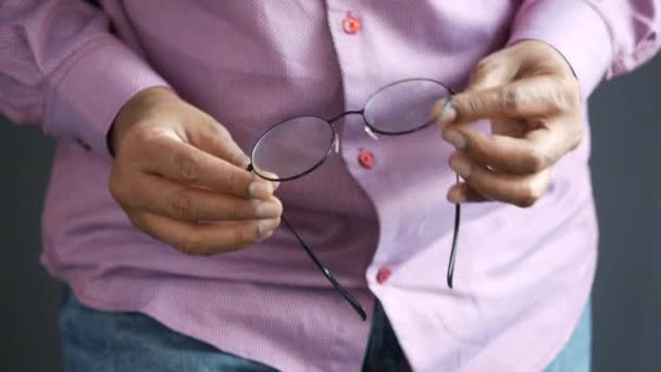 Primer plano de la mano del hombre sosteniendo gafas viejas — Vídeo de stock