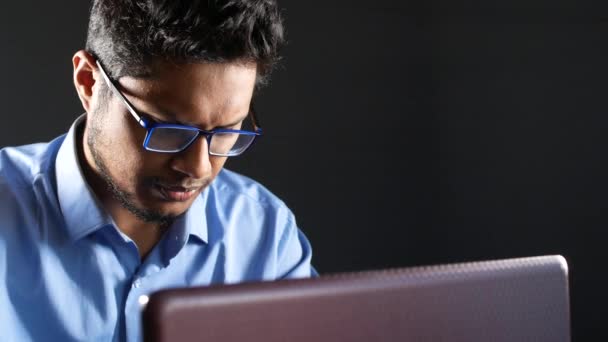 Молодой человек работает на ноутбуке, воруя персональные данные — стоковое видео
