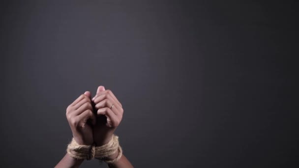 Hand gebonden met touw tegen zwarte achtergrond — Stockvideo