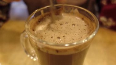 İnsan, kaşıkla kahve karıştırır..