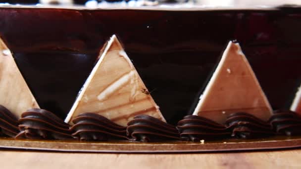 Σοκολάτα και κρέμα κέικ σε ένα πιάτο στο τραπέζι — Αρχείο Βίντεο