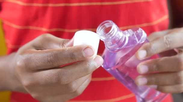 Hand hold a mouthwash liquid container against blue background — Stock Video