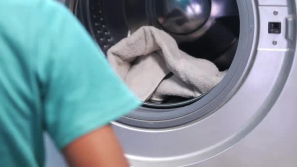 Man zet shirt in wasmachine. — Stockvideo