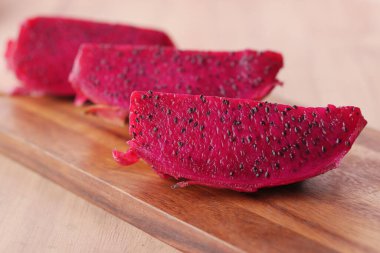 Bir dilim ejderha meyvesi doğrama tahtasında.