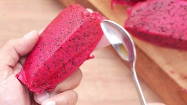 Bir kaşıkla bir dilim ejderha meyvesi yemek 