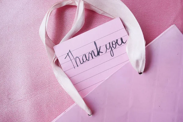 Primer plano de nota de agradecimiento en un papel pegajoso sobre fondo rosa — Foto de Stock