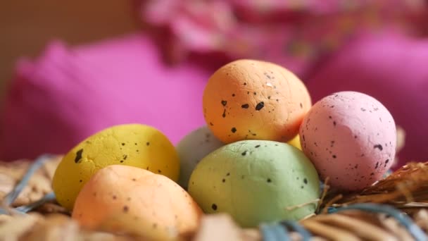 Concepto de Pascua con niño a mano recoger huevo colorido sobre fondo rosa. — Vídeo de stock