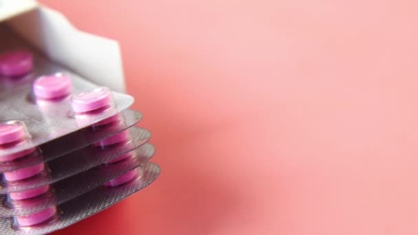 Primo piano di pillole di blister in un pacchetto su sfondo rosa — Video Stock