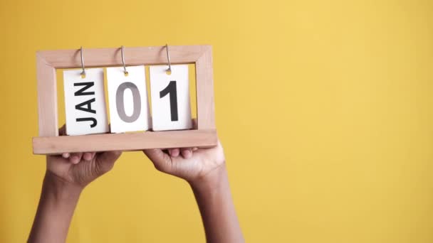 Calendario in legno impostato il 1 gennaio su sfondo giallo — Video Stock