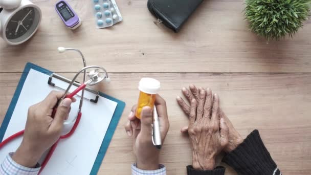 Arzt gibt seiner Seniorin eine Tablette — Stockvideo