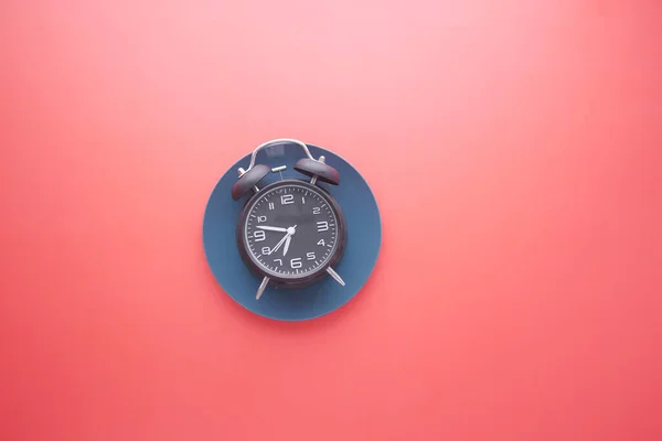 Kırmızı arkaplandaki alarmlı saat — Stok fotoğraf