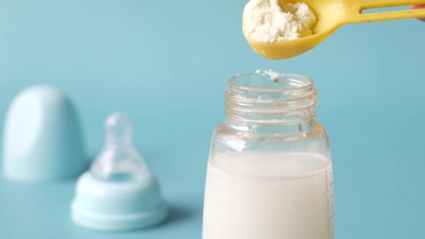 Primer plano de leche en polvo para bebés y fondo azul cuchara — Vídeos de Stock