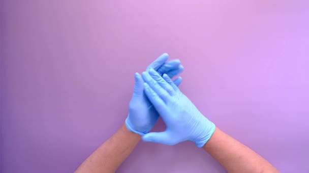 Mão médico com luvas médicas mostrando sinal de apoio no fundo roxo — Vídeo de Stock