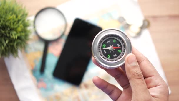 Ansicht von oben, um einen Kompass mit Reisekarte auf dem Tisch zu halten, — Stockvideo