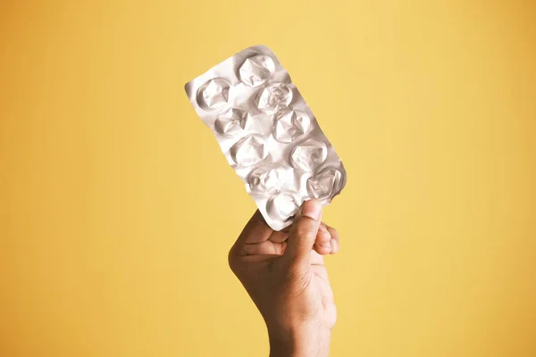 Met lege pillen van blisterverpakking tegen gele achtergrond — Stockfoto