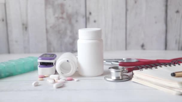Oksymetr pulsacyjny, tabletki medyczne i blister na stole — Wideo stockowe