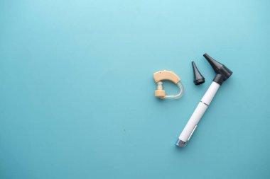 Açık yeşil arka planda işitme cihazı 