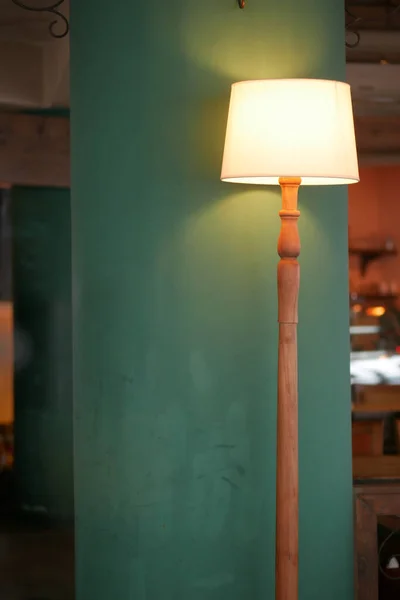 Eine Lampe in einem Café gegen eine hellgrüne Wand — Stockfoto