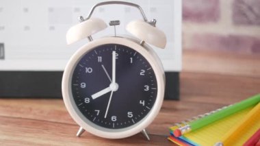 Ahşap arkaplanda eski çalar saat ve takvim.