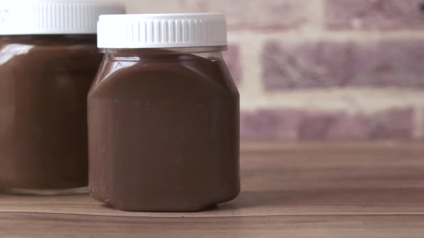 Σοκολάτα κρέμα φουντουκιού σε δοχείο στο τραπέζι — Αρχείο Βίντεο