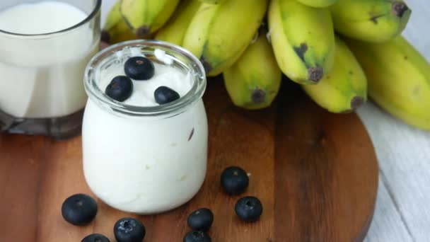 Menutup yogurt segar dengan berry biru dalam mangkuk — Stok Video