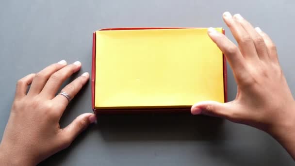Tmavě bílá čokoláda v krabici na šedém pozadí — Stock video