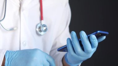 Beyaz önlüklü doktor akıllı telefon kullanıyor..