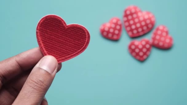 Women holding red heart on blue background — Stock Video