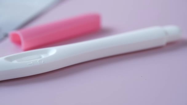 Тест на беременность на светлом фиолетовом фоне — стоковое видео
