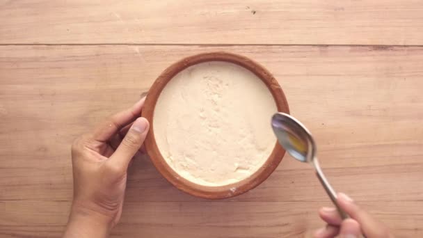 Bovenaanzicht van de mens hand eten verse yoghurt uit een kom — Stockvideo