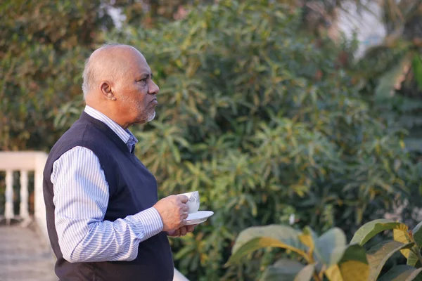Senior man die thee drinkt in de natuur — Stockfoto