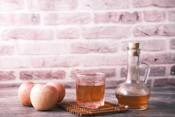 Vinaigre de pomme en bouteille en verre avec pomme verte fraîche sur la table — Photo