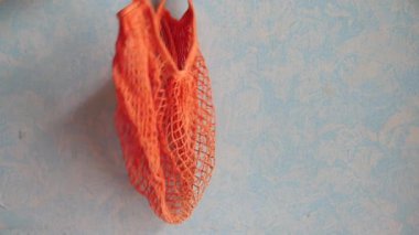 Taze portakal meyvesini alışveriş poşetine koy. 