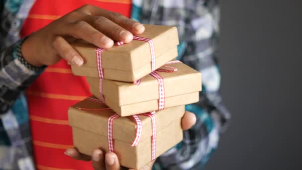 Молодий чоловік тримає стек саморобної подарункової коробки — стокове відео