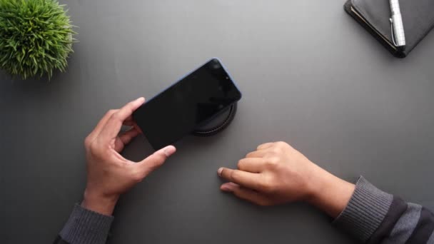 Nabíjení Smartphone pomocí bezdrátového nabíjecího panelu, horní pohled — Stock video