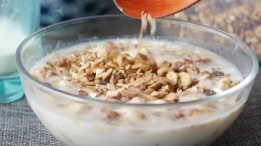 Musli gevreği sütle karıştırılmış olarak masada bir kasede. 